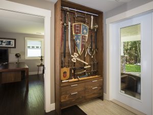 Burnett built the curio cabinet of walnut to house the client’s replica weapon and memorabilia collection. It has a grid structure to mount the swords on lucite dowels and magnets giving the appearance they’re floating in the cabinet. Photo: Bruce Murray, VisionFire Studios